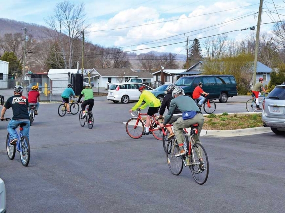 Members of BicycleHaywoodNC and residents of Haywood Pathways roll through the parking lot March 17. Pathways photo