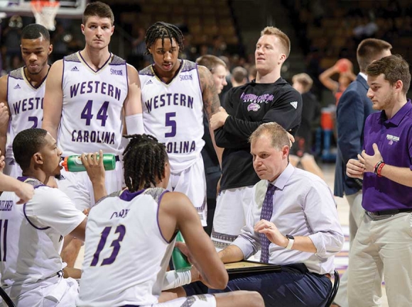 WCU men’s basketball coach Mark Prosser (center-right) counsels players during a recent game. Ashley Evans/WCU photo
