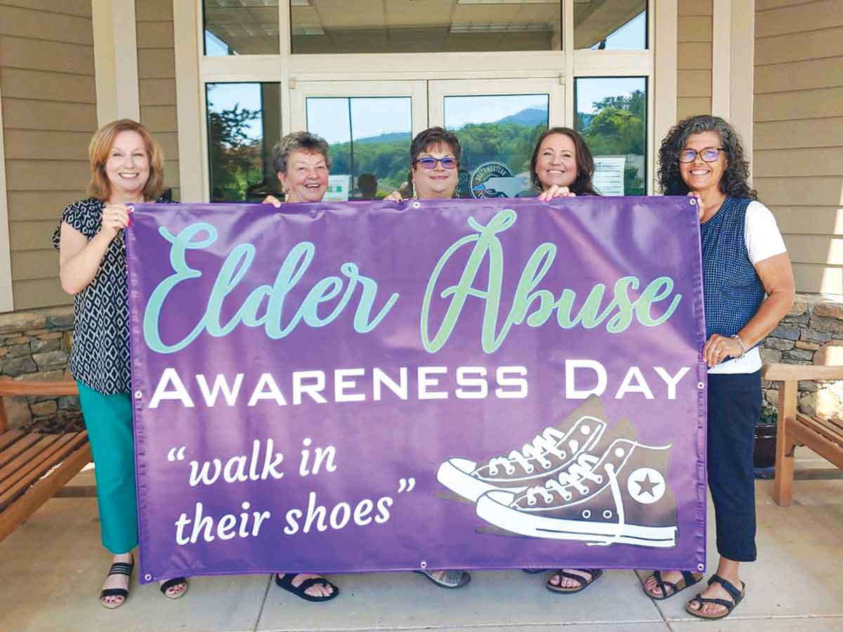 Area Agency on Aging staff hold up this year’s banner for Elder Abuse Awareness Day. Donated photo