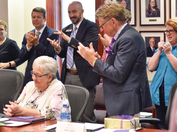 Trustees and university faculty applaud former Principal Chief Joyce Dugan (seated) during her last board meeting. Holly Kays photo