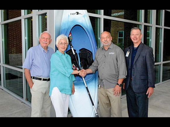 Phil and Connie Haire (left) present an Old Town brand kayak to Paul Wolf, director of SCC’s Outdoor Leadership program, and Brett Woods, director of the SCC Foundation. SCC photo