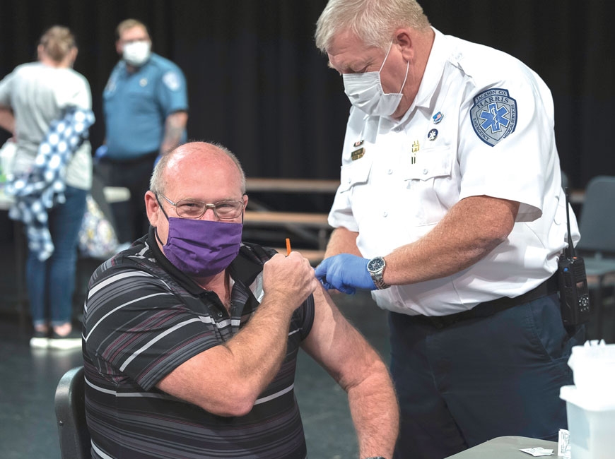 Mike Taylor receives a vaccination from EMS Supervisor Toby Moore. David Profitt/JCPS photo