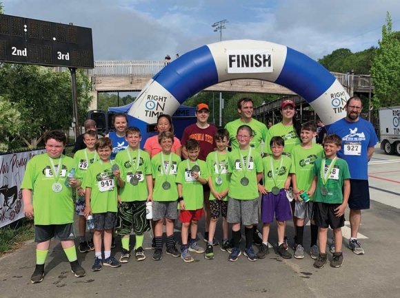 Carter Hollifield, (front row from left) Mason Rathbone, Trent Decker, Brooks Barbee, Henry Blackburn, August Menck, Tanner Justice, Dylan Douville, Levi Jackson, Aiden Harris, Jacob Davis, (second row from left) Katy Robinson (teacher), Lisa Ourada (running buddy), Connor Willis (running buddy), Cameron Nixon (teacher), Becca Brown (teacher), Alex Masciarelli (principal). Runners not pictured: Gavin Chouinard, Chase Perkins, Alexander Wenzel.