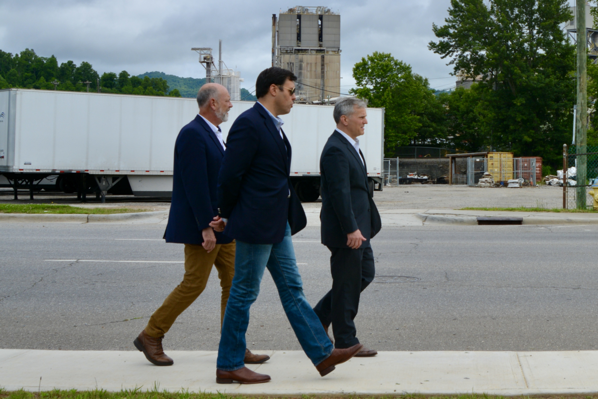 Haywood County Economic and Community Development Director David Francis (left to right) walks on Park Street with Canton Mayor Zeb Smathers and North Carolina Attorney General Josh Stein on May 31, 2023. 