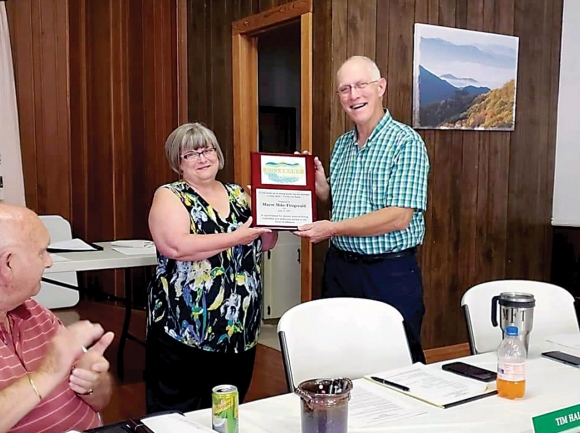 Mike Fitzgerald accepts a plaque recognizing his years of service form Town Clerk Debbie Coffey during his last meeting June 14. Donated photo