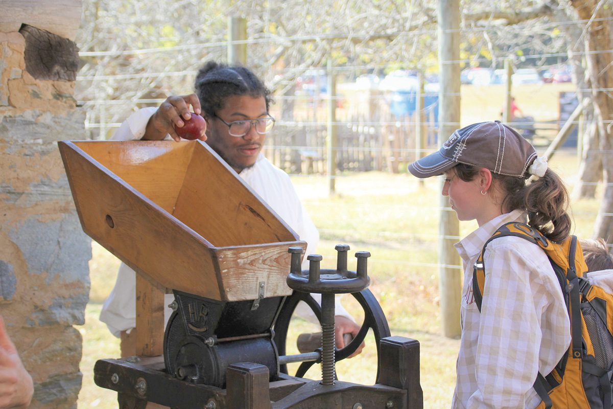 A park volunteer demonstrates apple pressing. NPS photo