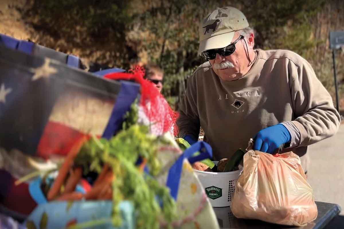 A volunteer at a recent MANNA event in Robbinsville works to load up some produce. MANNA FoodBank photo