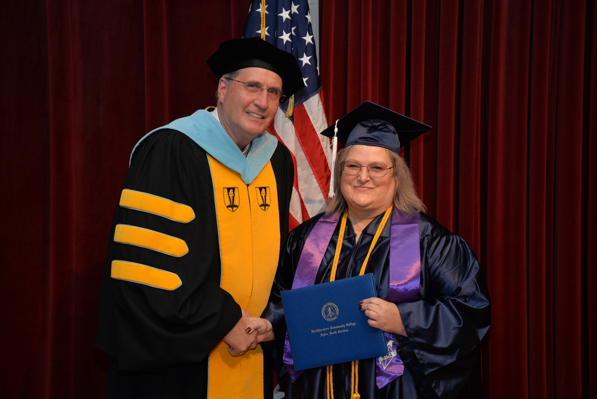 Dr. Don Tomas, SCC’s President, presents the final diploma cover of the 2019 fall commencement ceremony – the college’s most-recent indoor graduation. Southwestern will hold its first traditional commencement ceremony in two years on Dec. 10 in Sylva.