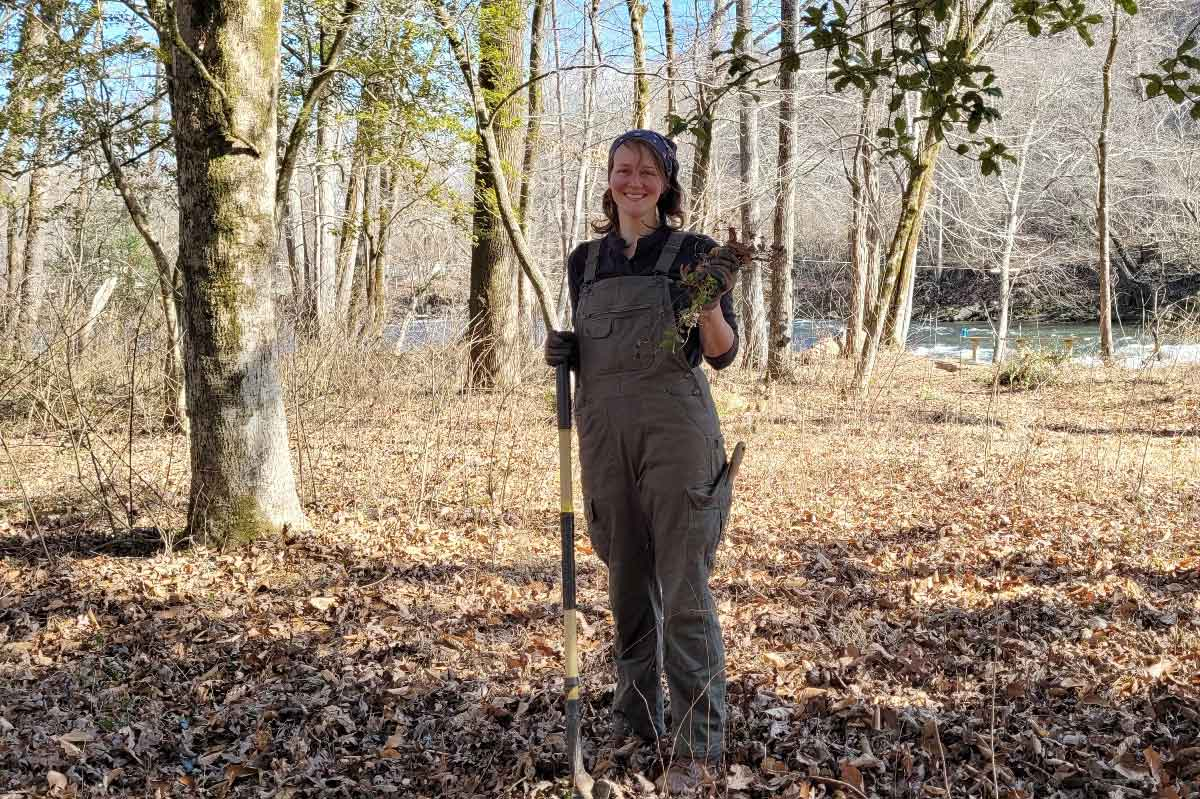 Nicole Harris shows off some Chinese privet plants she pulled up at Island Park on Feb. 10, 2021. MountainTrue photo