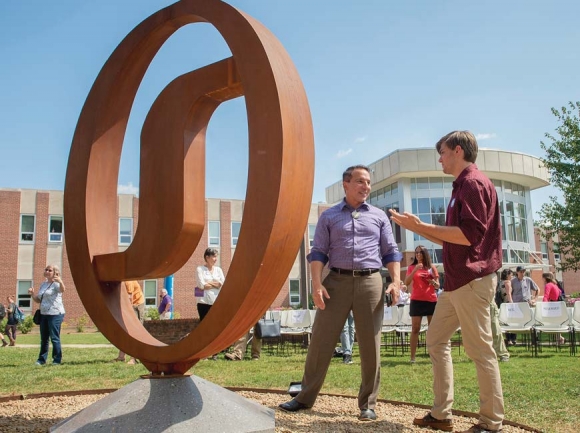 Todd Martin, a WCU fine arts student who produced the new ‘wi’ sculpture on campus, discusses that creation process with Richard Sneed, principal chief of the Eastern Band of Cherokee Indians.