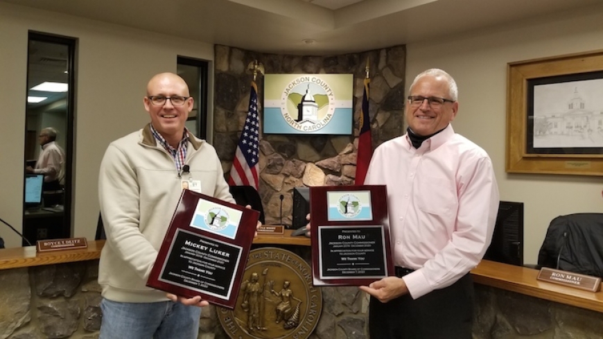 Outgoing commissioners Ron Mau (right) and Mickey Luker receive plaques commemorating their service. Chairman Brian McMahan (left) holds the plaque for Luker, who attended the meeting virtually. Jackson County photo