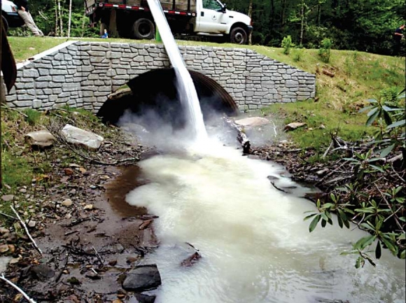 Limestone sand was added directly to the stream at Wolf Laurel Branch to reduce acidity of the water. Water clarity returned to normal after 30 minutes. Donated photo