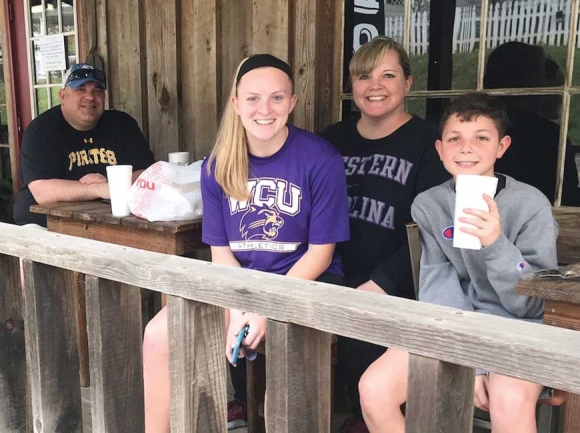 Junior nursing student Ashlee Owens (in purple) enjoys some takeout barbecue with          her mother, uncle and cousin after an unexpectedly early move-out from Western Carolina University. Holly Kays photo
