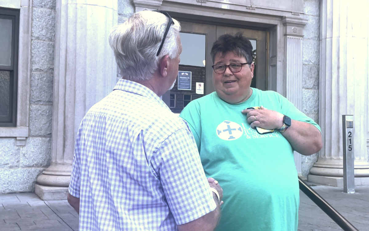 Dennis Thurman (left) and Helen Ryde shake hands after a prayer meeting held by the Haywood Baptist Association on June 28.